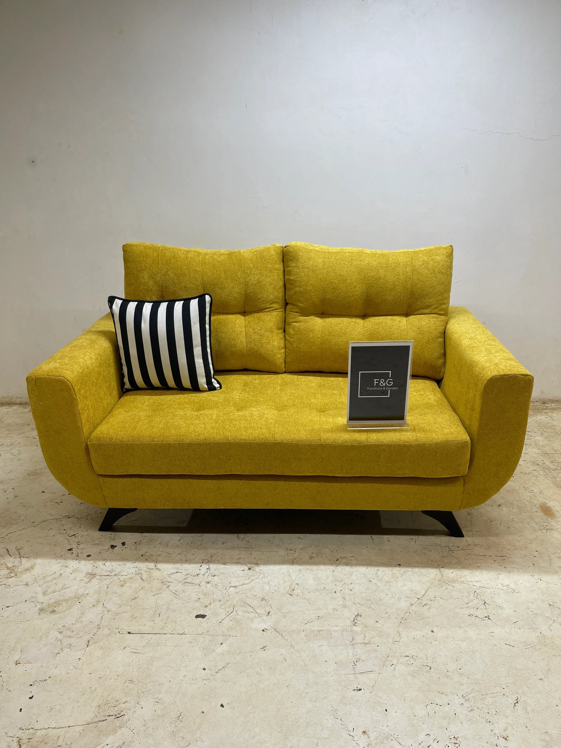 Yellow modern fabric sofa with tufted cushions and black-and-white striped pillow in minimal room