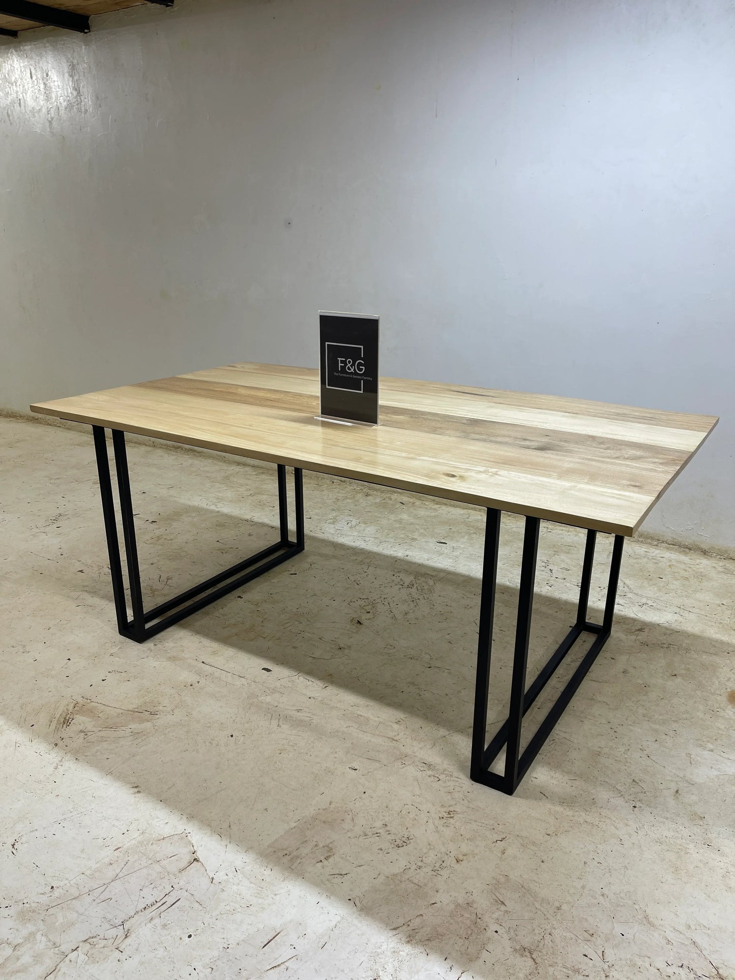 Modern rectangular wooden table with light wood top and black metal legs in minimalist room