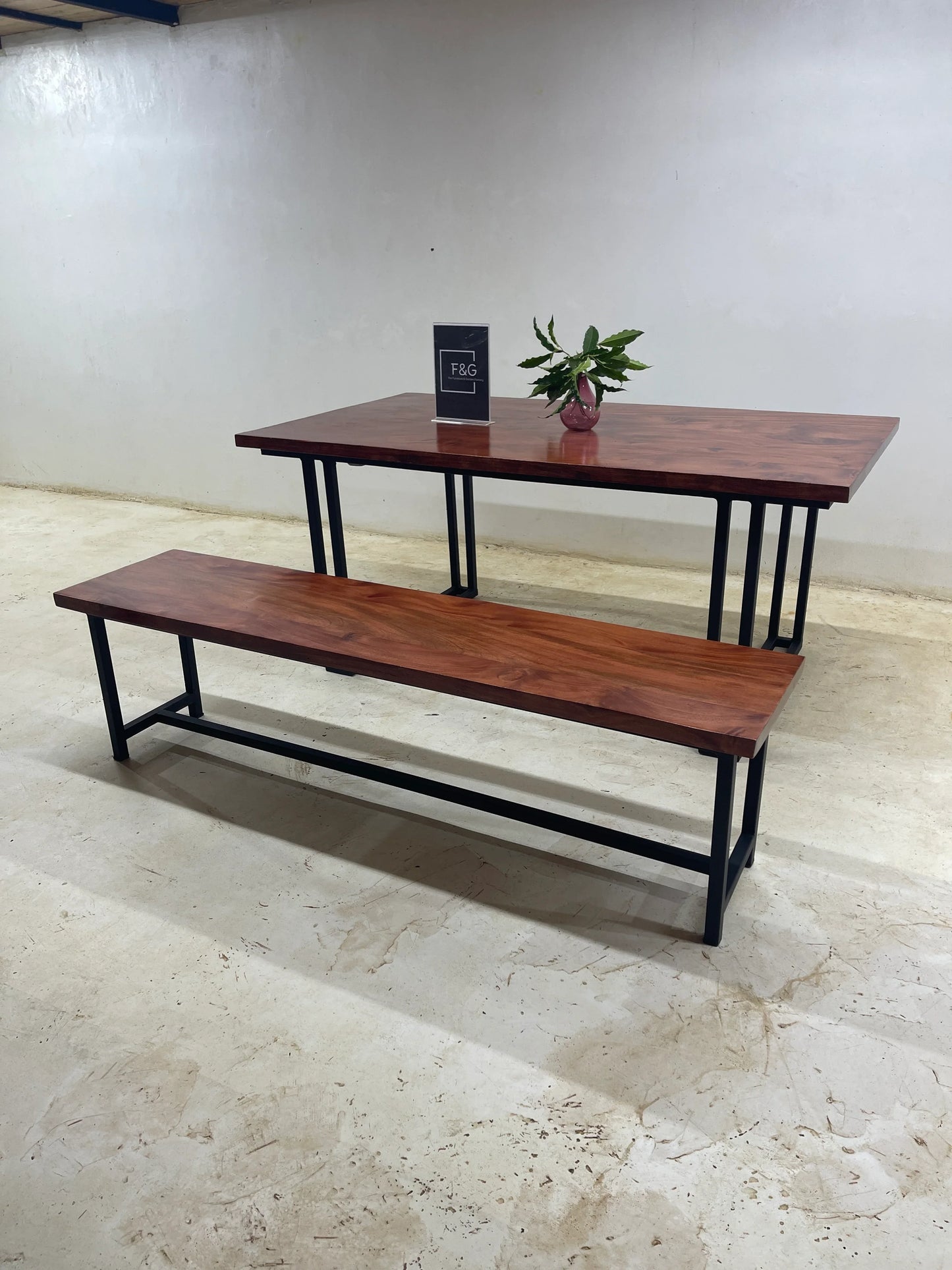 Wooden dining table with matching bench and black metal legs in minimalist room